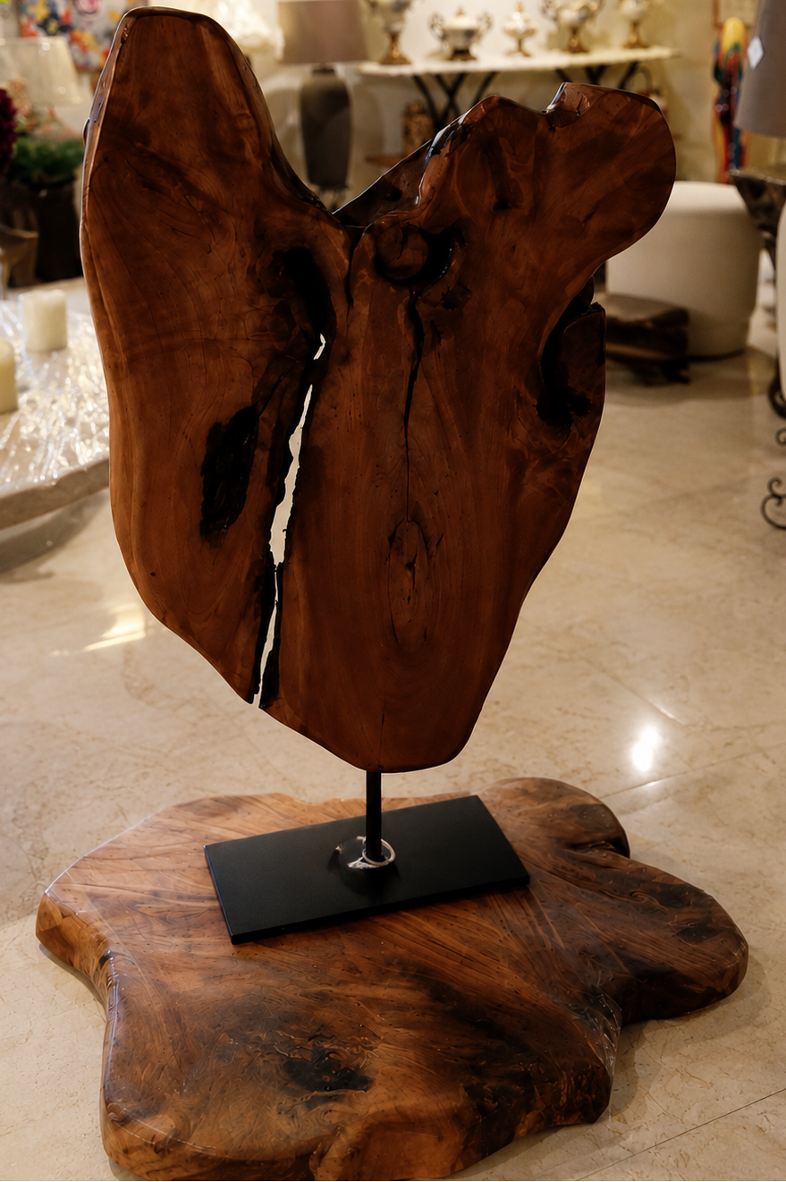 Wooden sculpture on a stand in an indoor setting with decor elements.