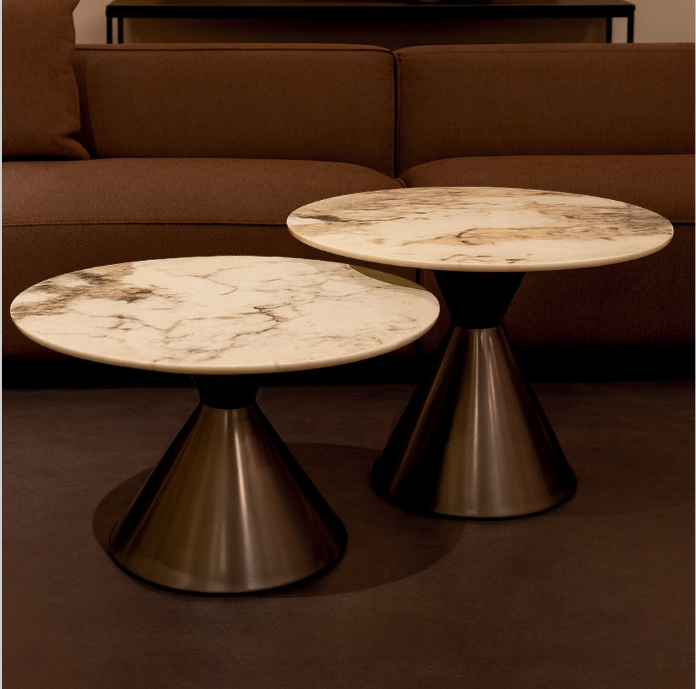 Two marble-top tables with metal bases in a room with a brown sofa.