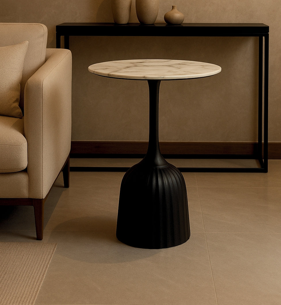 Round side table with marble top and black base in a living room setting