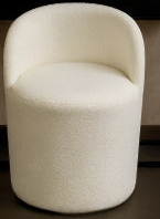 White upholstered chair in a room with decorative wall art and vases.