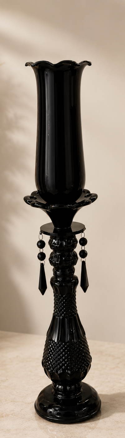 Two black candle holders with decorative elements on a neutral background