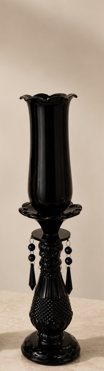 Two black candle holders with decorative elements on a neutral background