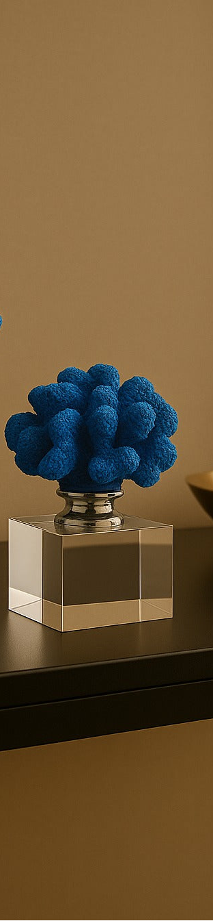 Two blue coral-like sculptures on clear stands against a brown wall.