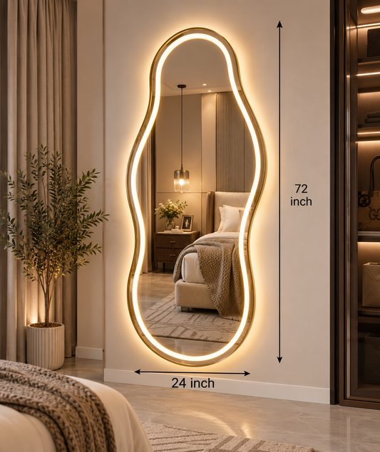 An asymmetrical full-length LED lighted wall mirror with a warm glowing organic outline, shown in a bedroom setting. Black dimension arrows indicate a height of 72 inches and a width of 24 inches.