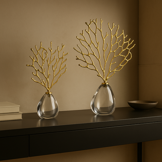 Two decorative vases with gold branch-like structures on a dark surface against a brown wall.