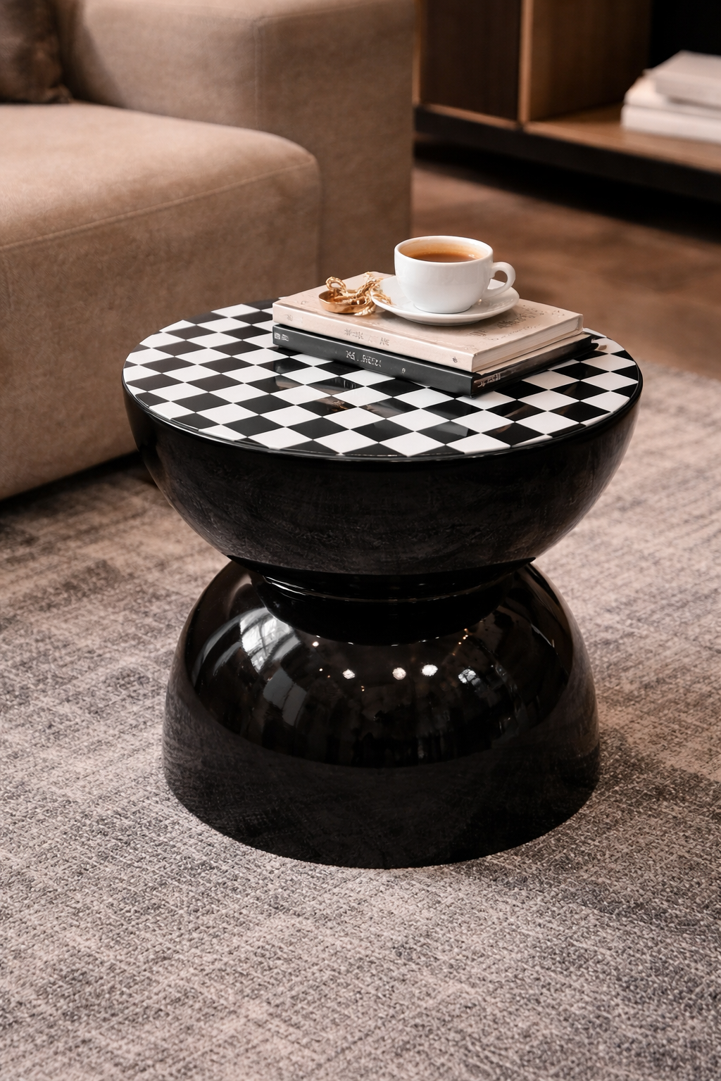 Black and white checkered side table with a cup of coffee and book in a living room setting.