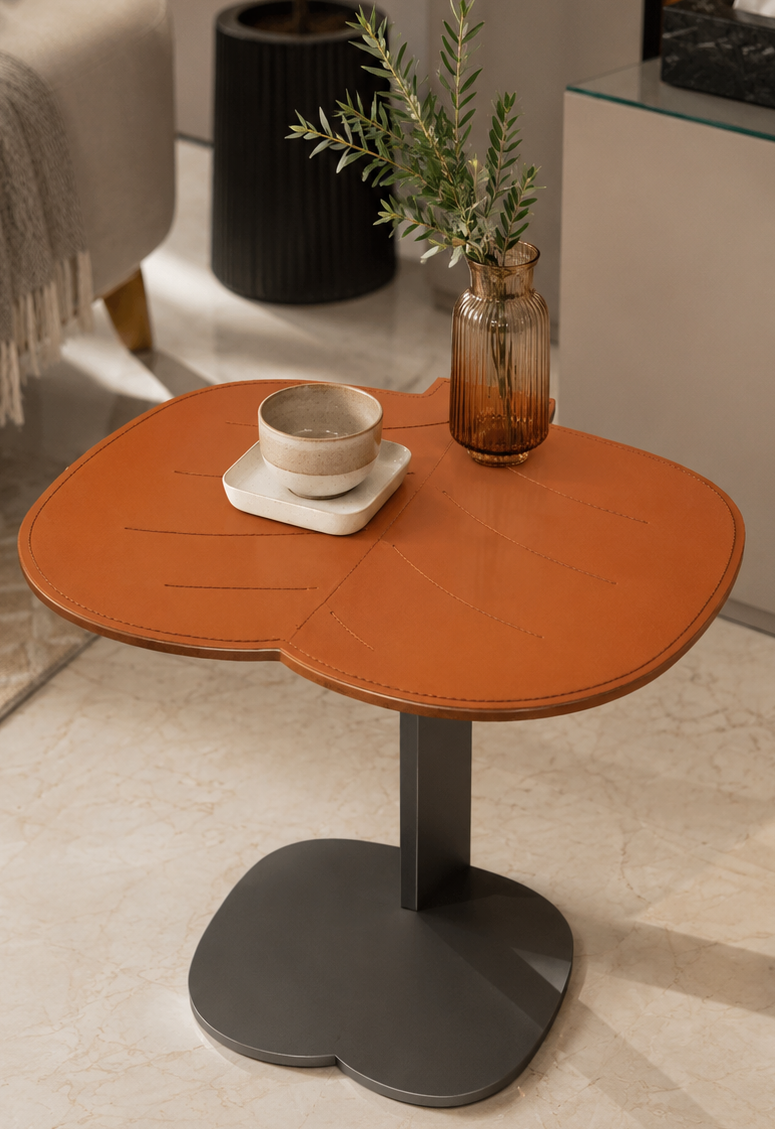 Small round wooden table with a black base in a living room setting.