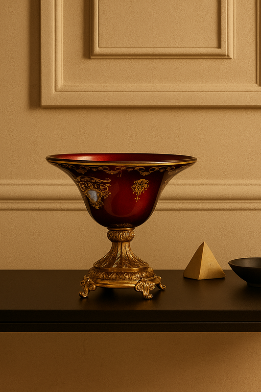 Decorative red and gold bowl on a dark surface with a beige wall background