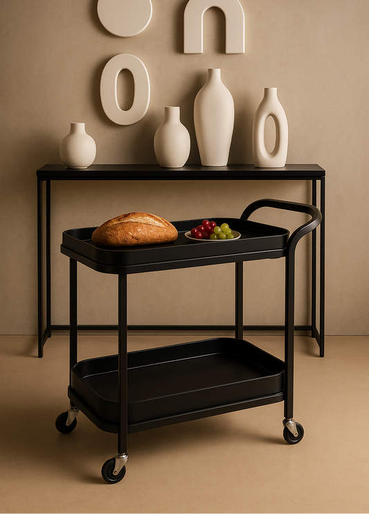 Black serving cart with bread and fruit on a beige background, featuring decorative vases and wall art.