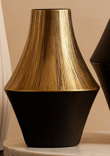Two decorative vases with black and gold finishes on a marble base against a beige wall.