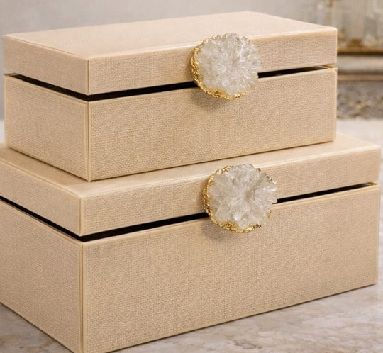 Beige decorative boxes with crystal-like embellishments on a neutral background