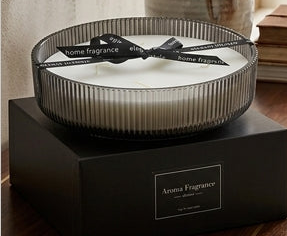 Candle with a black bow on a wooden table in a cozy living room.