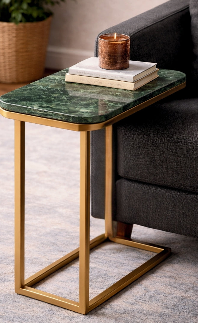 Small side table with green marble top and gold frame next to a gray sofa.