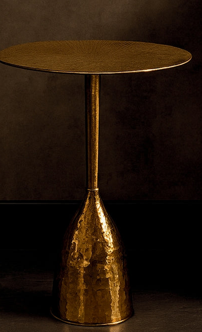 Gold side table with a textured base on a dark background