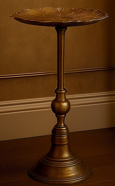 Bronze pedestal table against a brown wall