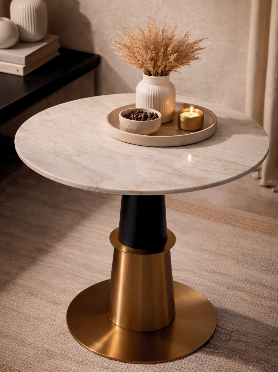 Round marble table with gold base in a room setting