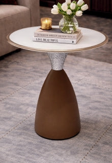 Small round table with a brown base and white top, featuring books and a vase on it.