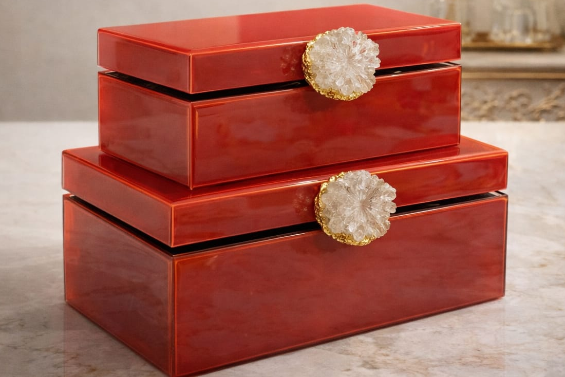 Set of three red decorative boxes with gold accents on a marble surface, featuring the brand 'DSYN'.